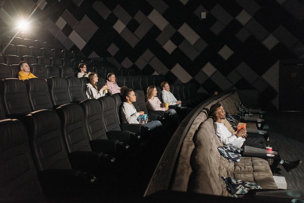 Petite salle de projection, quelques spectateurs devant l'écran